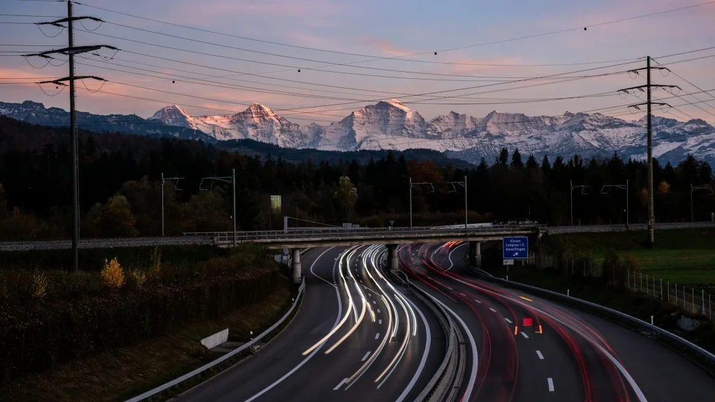 Estrada de montanha nos Alpes suíços com carro em movimento