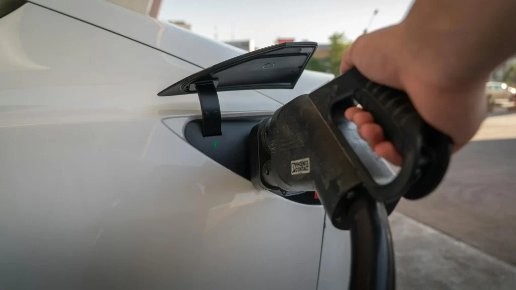 Carregamento de carro elétrico em estação pública com cabo verde