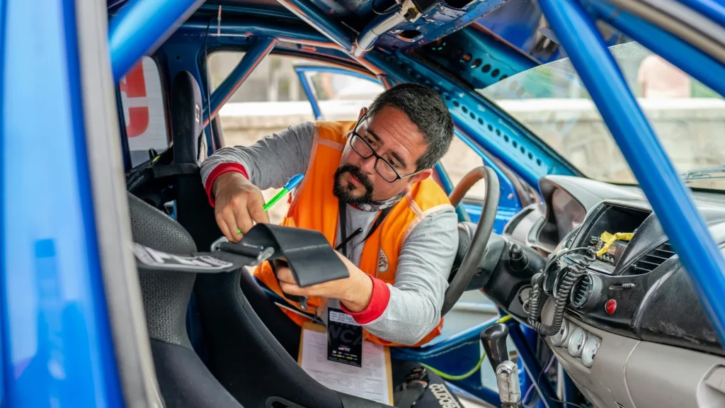Técnico com prancheta a inspeccionar um automóvel