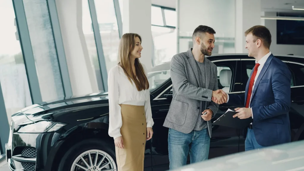 Aperto de mão entre cliente e vendedor em stand automóvel
