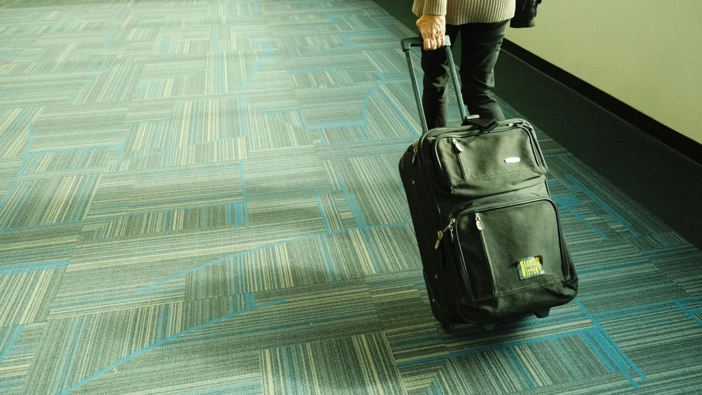 Passageiro em aeroporto com mala de viagem